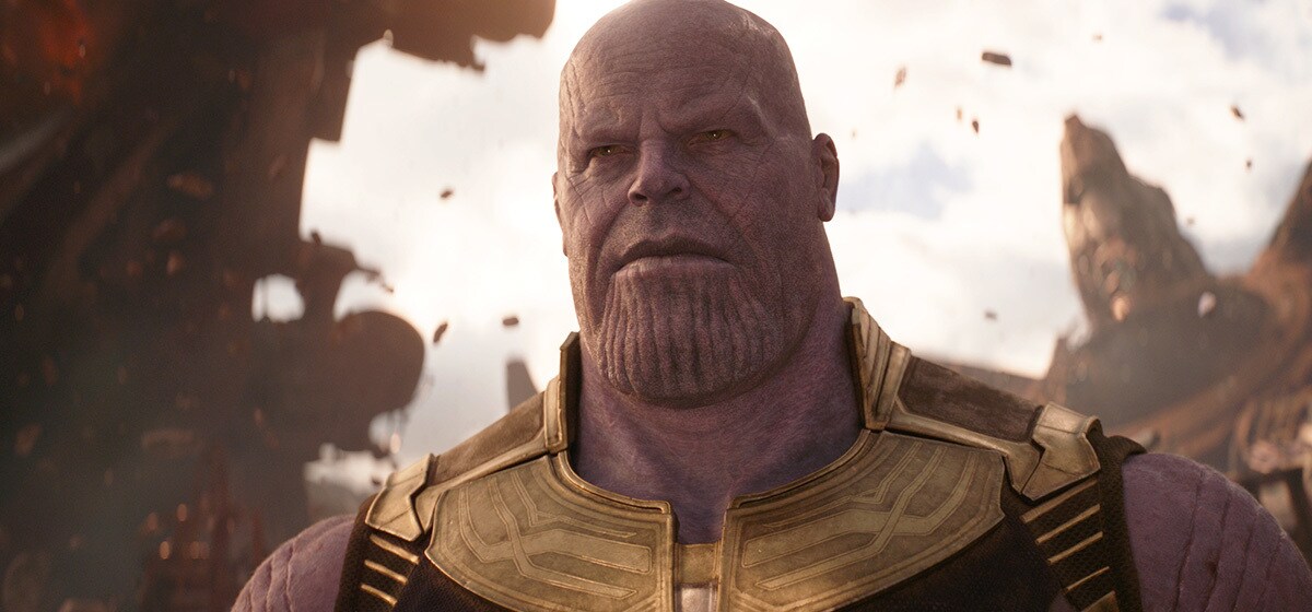 Avengers: Infinity War (2018): Thanos wears gold armor in a close-up against a backdrop of broken structures